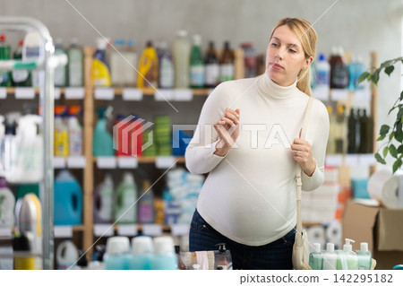 Pregnant woman choosing personal care and cleaning products in store Pregnant woman choosing personal care and cleaning products in store 142295182