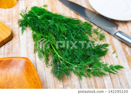 Fresh dill sprigs on kitchen table 142295220