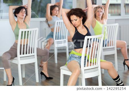 Women participant of dance group perform basic elements of heel dance in staggered manner. Development of female sexuality Women participant of dance group perform basic elements of heel dance in staggered manner. Development of female sexuality 142295254
