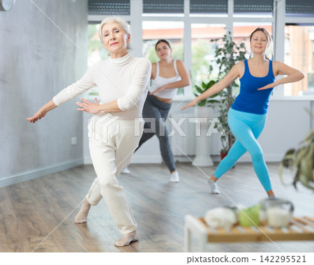 Happy women practicing aerobics in light fitness studio 142295521