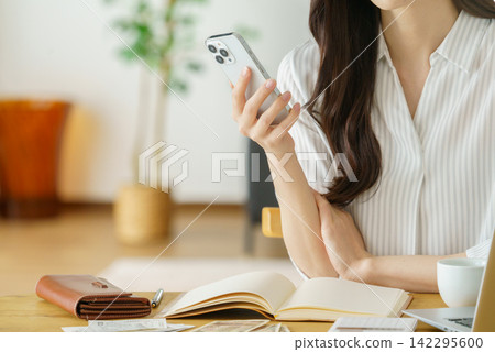 一位中年婦女操作智慧型手機的特寫鏡頭,展現了她纖纖玉手的畫面。 一位中年婦女操作智慧型手機的特寫鏡頭,展現了她纖纖玉手的畫面。 142295600