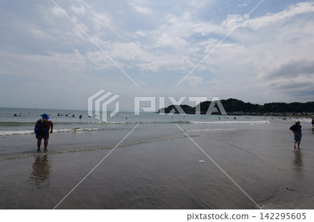 Kamakura Beach in Japan with people enjoying the sea and sandy shore Kamakura Beach in Japan with people enjoying the sea and sandy shore 142295605