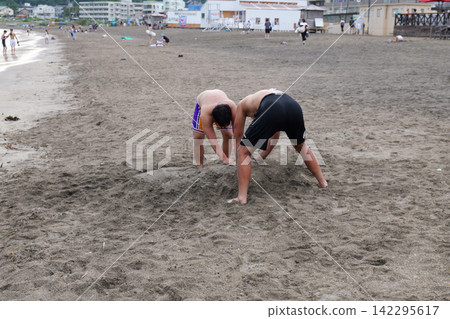 Kamakura Beach in Japan with people enjoying the sea and sandy shore 142295617