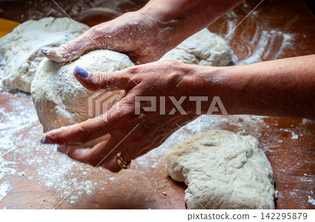 Close-up of mother hands shaping fresh bread dough ball Close-up of mother hands shaping fresh bread dough ball 142295879