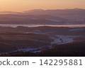 Mountain ranges shrouded in the morning glow and snow-covered fields 142295881