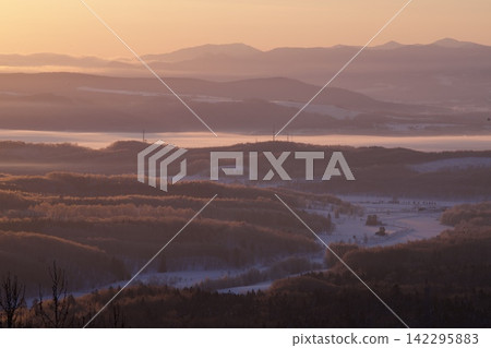 A forest of frost-covered trees and snow-covered farmland, shining in the morning sun. A forest of frost-covered trees and snow-covered farmland, shining in the morning sun. 142295883