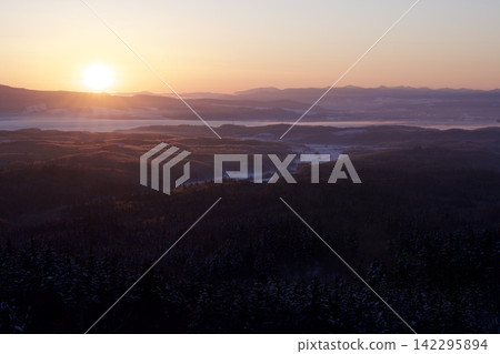 Snow-covered hills and a sea of clouds bathed in the morning sun Snow-covered hills and a sea of clouds bathed in the morning sun 142295894