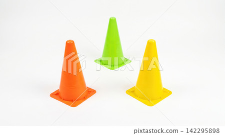 Three colorful plastic traffic safety cones arranged on a white studio background with isolated construction background colorful equipment direction guidance transportation automotive Three colorful plastic traffic safety cones arranged on a white studio background with isolated construction background colorful equipment direction guidance transportation automotive 142295898