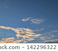 Clouds and blue sky faintly tinged with the setting sun 142296322