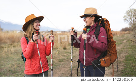 Two happy girlfriends are having fun camping. A lesbian couple in love is smiling and enjoying their time together outdoors Two happy girlfriends are having fun camping. A lesbian couple in love is smiling and enjoying their time together outdoors 142298169