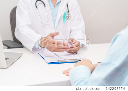 Doctor and patient having a medical consultation for Teal and white ribbon concept of January Cervical Cancer Awareness month, September Ovarian Cancer, PCOS, April Sexual Assault Doctor and patient having a medical consultation for Teal and white ribbon concept of January Cervical Cancer Awareness month, September Ovarian Cancer, PCOS, April Sexual Assault 142298354