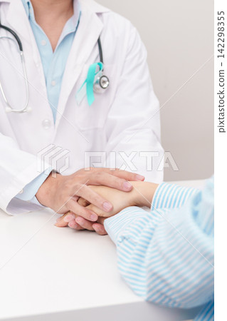 doctor holding patient hand to comfort and support with empathy. Teal and white ribbon concept of January Cervical Cancer Awareness month, September Ovarian Cancer, PCOS, April Sexual Assault doctor holding patient hand to comfort and support with empathy. Teal and white ribbon concept of January Cervical Cancer Awareness month, September Ovarian Cancer, PCOS, April Sexual Assault 142298355