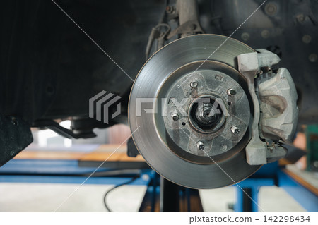 Brake system detail, high-performance caliper on car disc brakes. Automotive repair service for mechanical maintenance. Brake system detail, high-performance caliper on car disc brakes. Automotive repair service for mechanical maintenance. 142298434