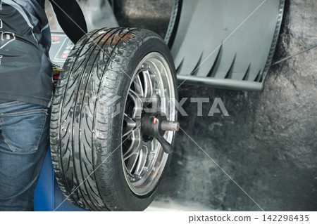 Closeup of car wheel alignment at auto repair center. Vehicle maintenance service in an automotive workshop Closeup of car wheel alignment at auto repair center. Vehicle maintenance service in an automotive workshop 142298435