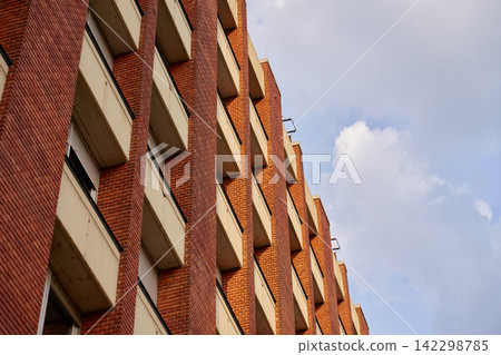 Modern red brick building facade with repeating windows Modern red brick building facade with repeating windows 142298785