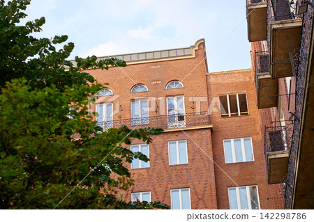 Red Brick Building with Balconies and Arched Windows Red Brick Building with Balconies and Arched Windows 142298786
