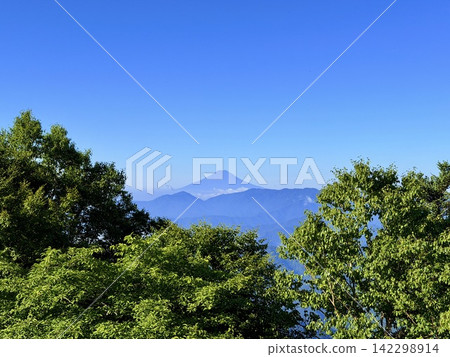 從東京最高峰雲取山頂眺望富士山和夏季山景,周圍環繞著藍天和積雲,以及雲取山避難小屋。 從東京最高峰雲取山頂眺望富士山和夏季山景,周圍環繞著藍天和積雲,以及雲取山避難小屋。 142298914