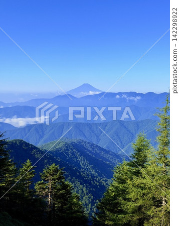 從東京最高峰雲取山頂眺望富士山和夏季山景，周圍環繞著藍天和積雲，以及雲取山避難小屋。 142298922