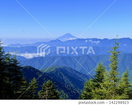 從東京最高峰雲取山頂眺望富士山和夏季山景，周圍環繞著藍天和積雲，以及雲取山避難小屋。 142298923