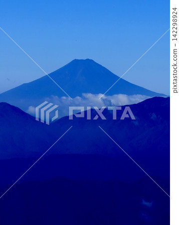從東京最高峰雲取山頂眺望富士山和夏季山景,周圍環繞著藍天和積雲,以及雲取山避難小屋。 從東京最高峰雲取山頂眺望富士山和夏季山景,周圍環繞著藍天和積雲,以及雲取山避難小屋。 142298924