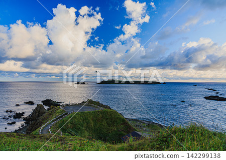 The observation deck at Sukoton Cape on Rebun Island bathed in the morning sun, and the spectacular view of Todojima Island floating offshore. The observation deck at Sukoton Cape on Rebun Island bathed in the morning sun, and the spectacular view of Todojima Island floating offshore. 142299138