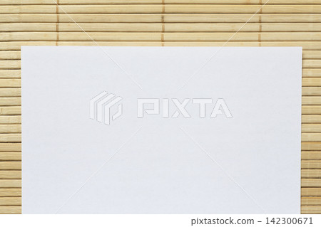 blank white sheet of paper on bamboo mat blank white sheet of paper on bamboo mat 142300671