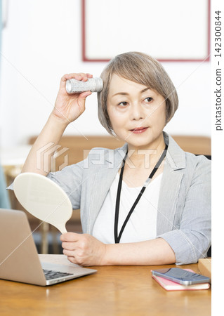 Senior women checking their appearance during breaks at the office. 142300844