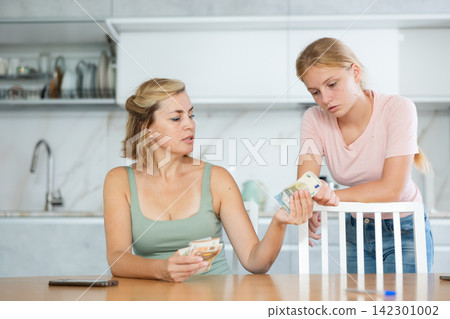 Mother gives teenage daughter bills small amount of pocket money. Mother gives teenage daughter bills small amount of pocket money. 142301002