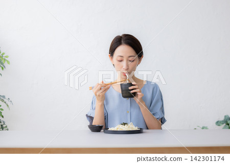 一名婦女正在吃 Zaru Udon 一名婦女正在吃 Zaru Udon 142301174