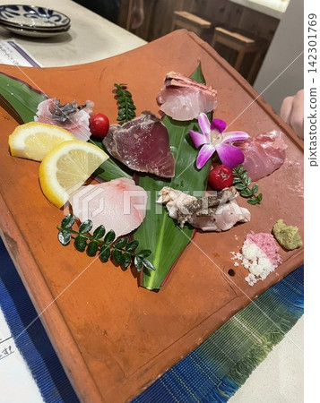 A photo taken at a resort hotel in Ishigaki Island, showing a table adorned with colorful dishes, fruits, and tropical flowers. Tropical. A photo taken at a resort hotel in Ishigaki Island, showing a table adorned with colorful dishes, fruits, and tropical flowers. Tropical. 142301769