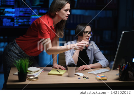 Tired manager works on important report late at night in office Tired manager works on important report late at night in office 142302052