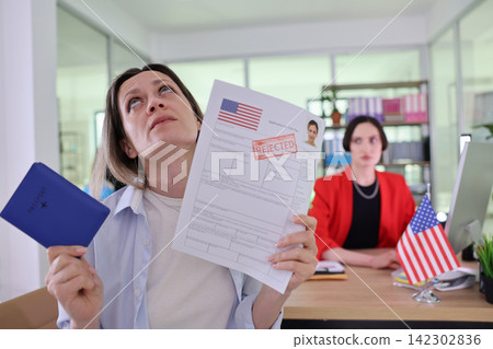 Disappointed woman holds passport and rejected visa application Disappointed woman holds passport and rejected visa application 142302836