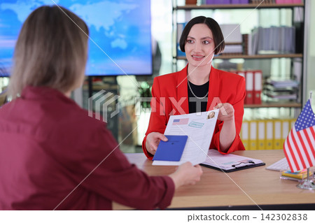 Lawyer gives approved visa documents and passport to client Lawyer gives approved visa documents and passport to client 142302838