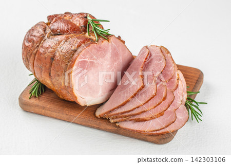 Sliced smoked ham on a wooden cutting board with fresh rosemary sprigs, showcasing the texture and color of the meat against a light background Sliced smoked ham on a wooden cutting board with fresh rosemary sprigs, showcasing the texture and color of the meat against a light background 142303106