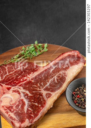 Raw Marbled Tomahawk Steak with Peppercorns Raw Marbled Tomahawk Steak with Peppercorns 142303297