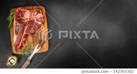 Raw Tomahawk Steak with Herbs and Carving Fork Raw Tomahawk Steak with Herbs and Carving Fork 142303302
