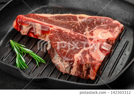 Raw T Bone Steak with Rosemary in Grill Pan Raw T Bone Steak with Rosemary in Grill Pan 142303312