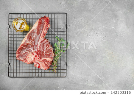 Raw T Bone Steak with Thyme and Oil on Rack Raw T Bone Steak with Thyme and Oil on Rack 142303316