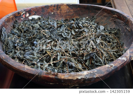 Dried indigo leaves, the raw material for traditional indigo dyeing. Dried indigo leaves, the raw material for traditional indigo dyeing. 142305159