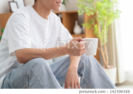 一位年輕男子在家喝咖啡 142306388