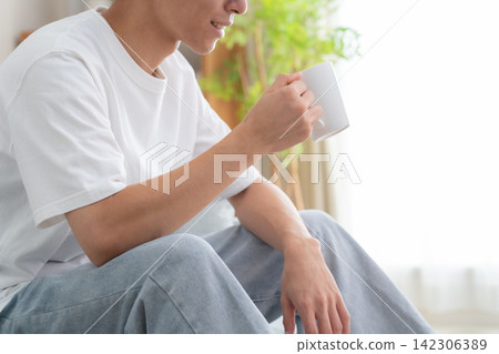一位年輕男子在家喝咖啡 142306389