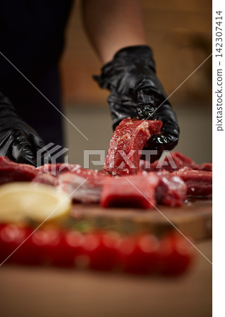 Preparing raw meat with seasoning for cooking Preparing raw meat with seasoning for cooking 142307414