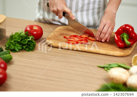 Person cutting fresh red pepper for healthy meal Person cutting fresh red pepper for healthy meal 142307694