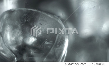 Ice cube macro shot showing frozen water texture, cold crystal surface and abstract silver reflections Ice cube macro shot showing frozen water texture, cold crystal surface and abstract silver reflections 142308300