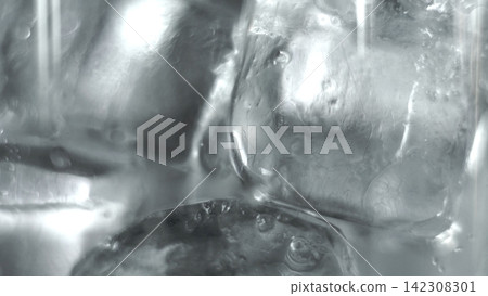 Ice cubes melting in cool liquid, creating refreshing texture and abstract patterns, cold drink concept 142308301