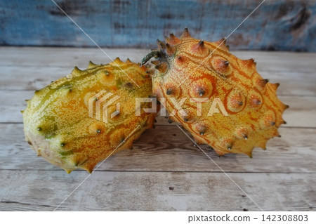 Horned melon exotic fruit on wooden background Horned melon exotic fruit on wooden background 142308803