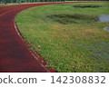 Athletics track after heavy rain with flooded grass, making outdoor training difficult in autumn 142308832