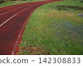 Athletics track after heavy rain with flooded grass, making outdoor training difficult in autumn 142308833
