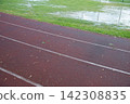 Athletics track after heavy rain with flooded grass, making outdoor training difficult in autumn 142308835