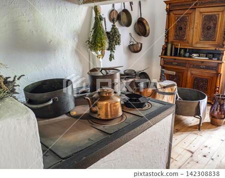 Vintage Rural Kitchen Interior With Antique Copper Kettle, Pots and Hanging Herbs on Wood Stove Vintage Rural Kitchen Interior With Antique Copper Kettle, Pots and Hanging Herbs on Wood Stove 142308838